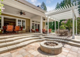 Paver patio with integrated landscape lighting and a seating wall at dusk in Charlotte, NC